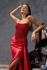Model wearing a strapless evening gown with a beaded corset bodice, draped satin skirt, and high side slit
