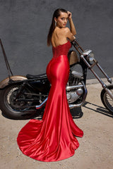 Model wearing a strapless evening gown with a beaded corset bodice, draped satin skirt, and high side slit