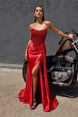Model wearing a strapless evening gown with a beaded corset bodice, draped satin skirt, and high side slit