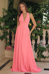 Model wearing a halter maxi dress featuring a plunging neckline, ruched waist, and flowing floor-length skirt