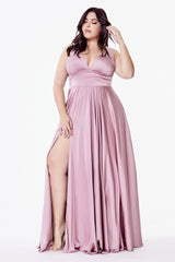 Woman wearing a pink evening gown with a high slit on a white background
