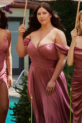 Woman in a pink dress standing outdoors with two other women in similar dresses.