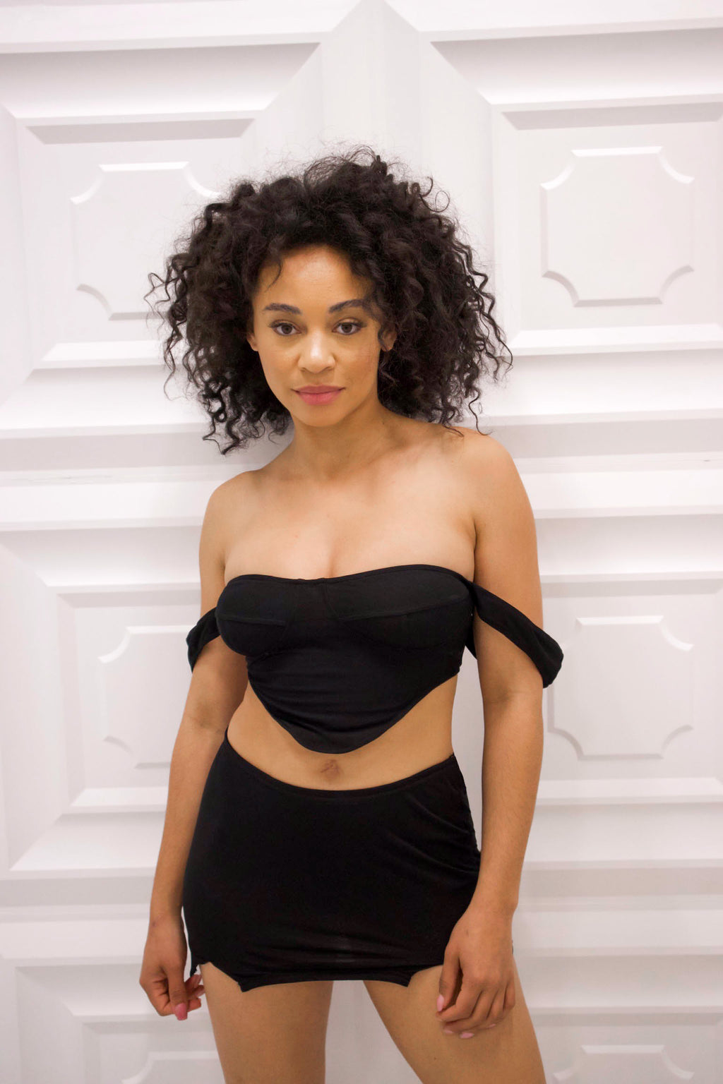 Off the shoulder crop top with matching mid rise mini skirt in black