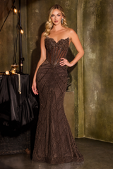 Woman in a brown strapless evening gown standing against a textured wall.