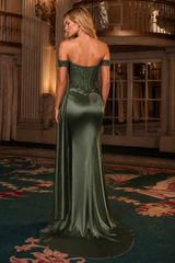 A woman wearing an off-the-shoulder dark green satin evening gown with a structured corset-style bodice, photographed from the back in an elegant indoor ballroom setting.