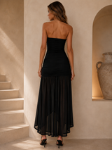 Strapless ruched bodycon maxi dress with a sheer asymmetrical mesh hem.
