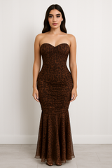 Strapless maxi dress with a sweetheart neckline, ruched bodice, bodycon fit through the hips, and flared sheer hemline in an animal print pattern.