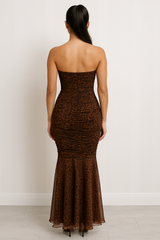 Strapless maxi dress with a sweetheart neckline, ruched bodice, bodycon fit through the hips, and flared sheer hemline in an animal print pattern.