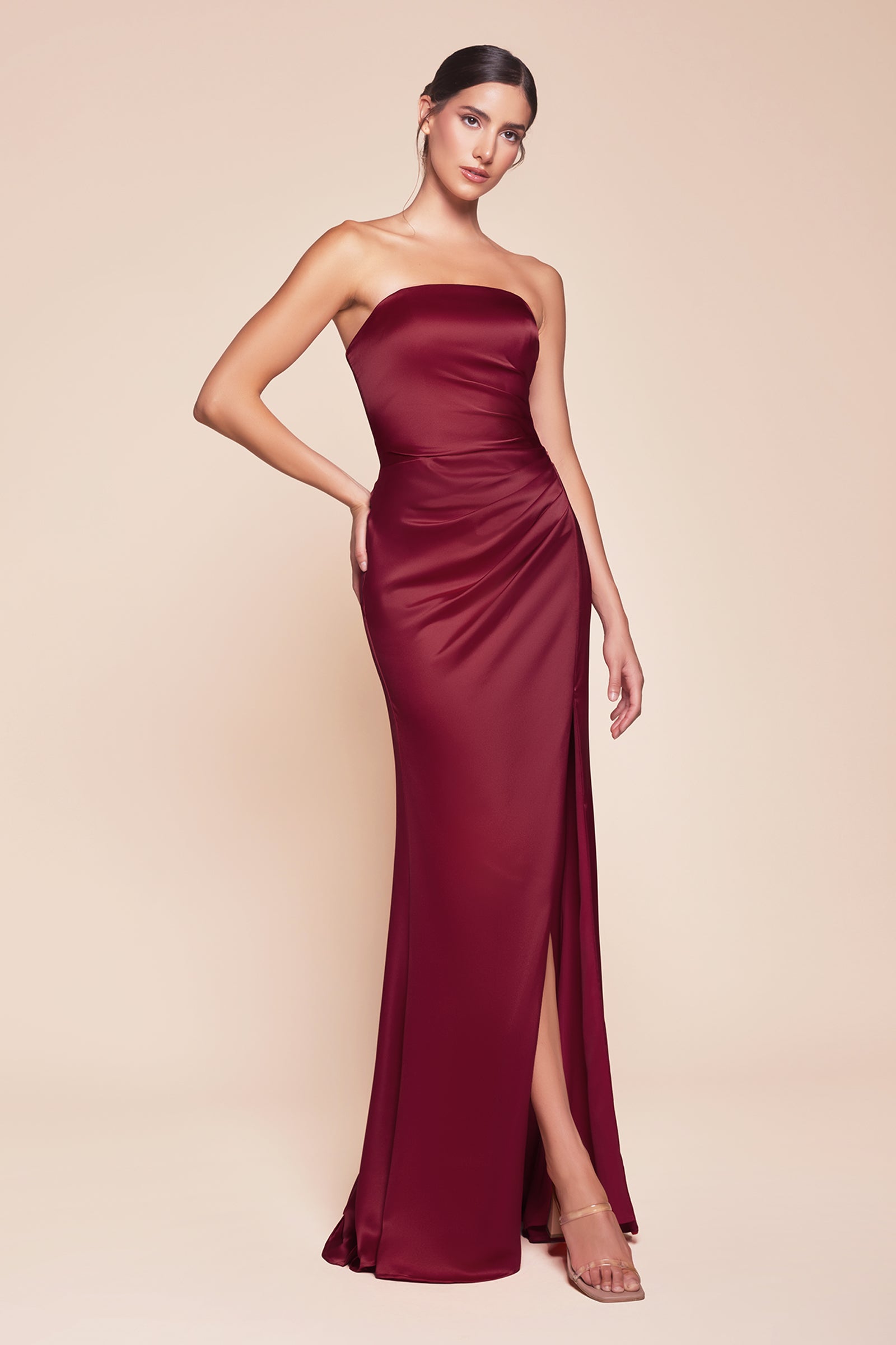 fitted strapless gown, crafted from luxe satin, features a sleek straight neckline, gathered waistline, and elegant leg slit