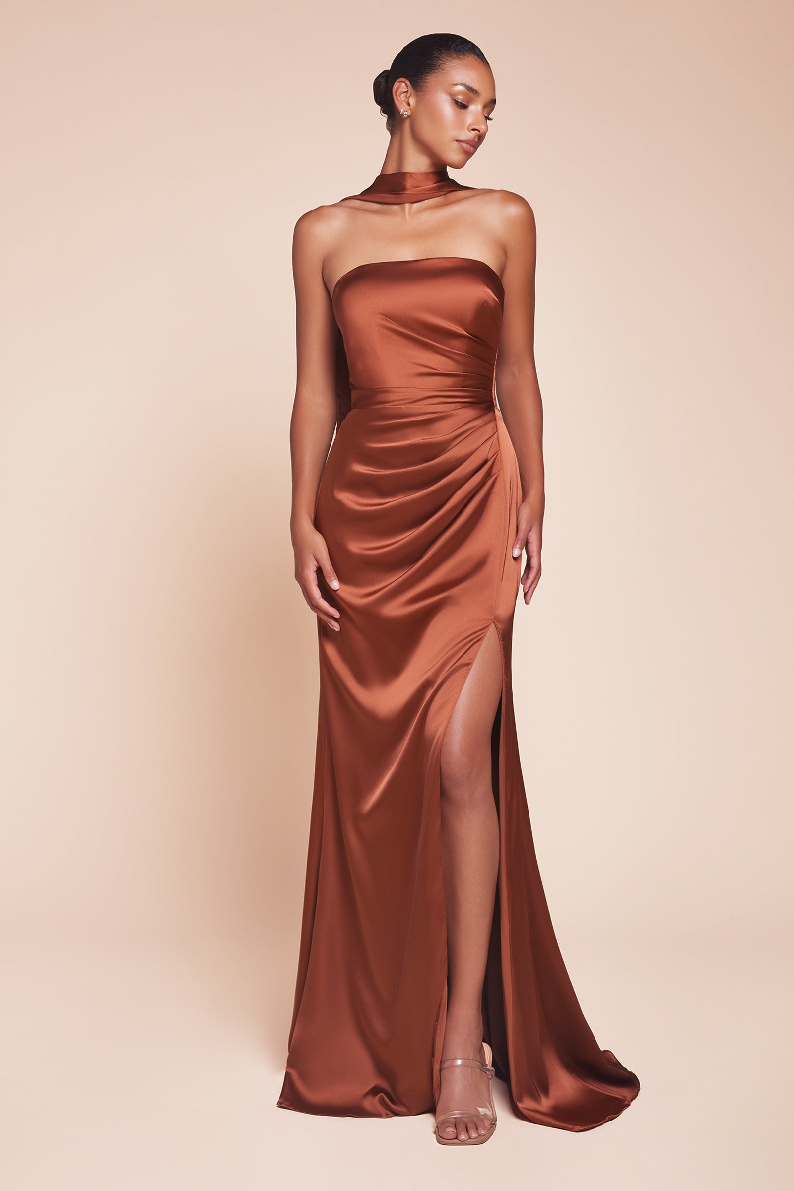 fitted strapless gown, crafted from luxe satin, features a sleek straight neckline, gathered waistline, and elegant leg slit