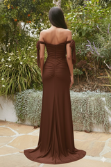 Woman in a brown off-shoulder gown standing in a garden setting