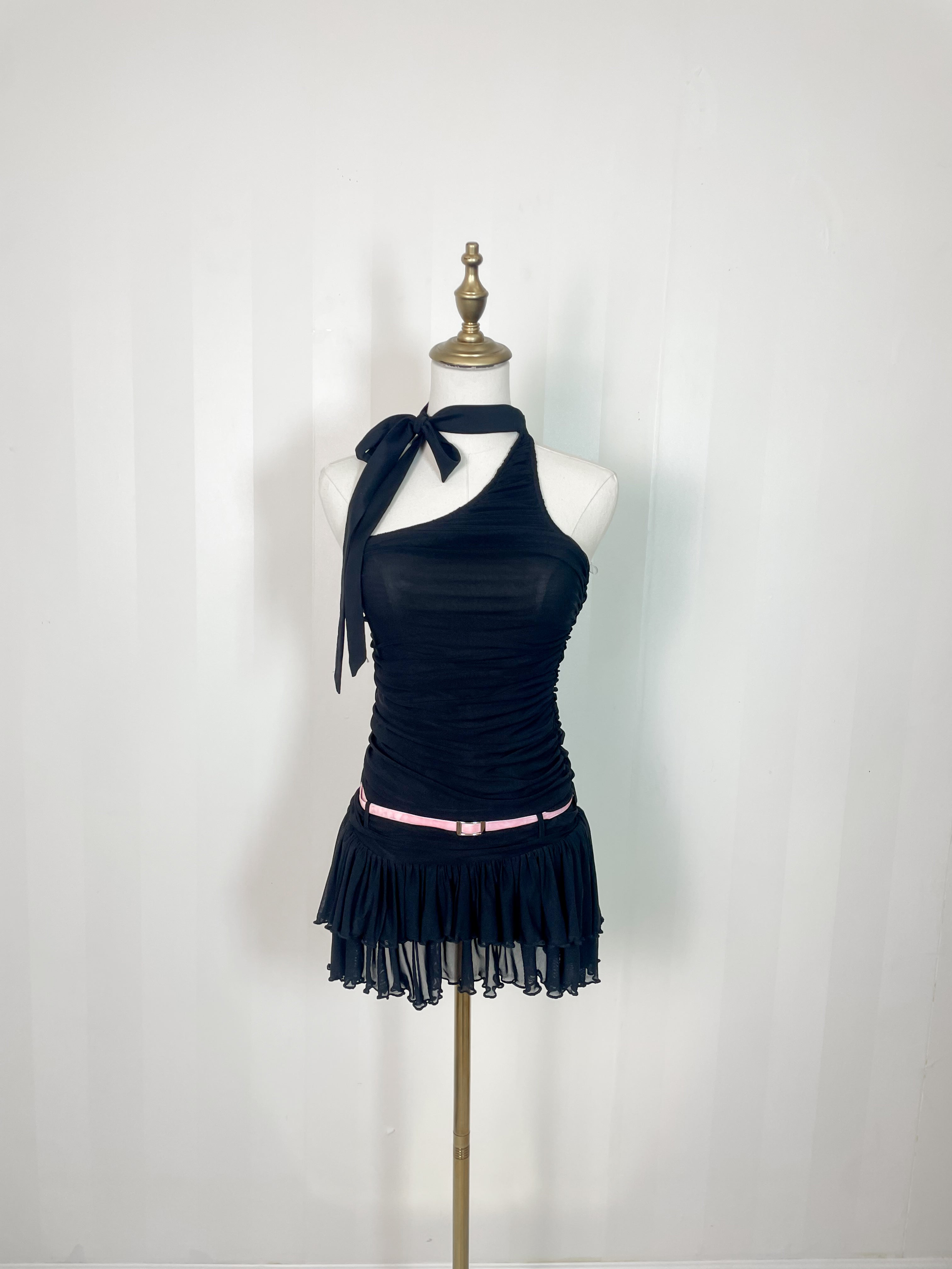 Black halter-neck ruched mini romper with ruffled hem and pink belt, displayed on mannequin
