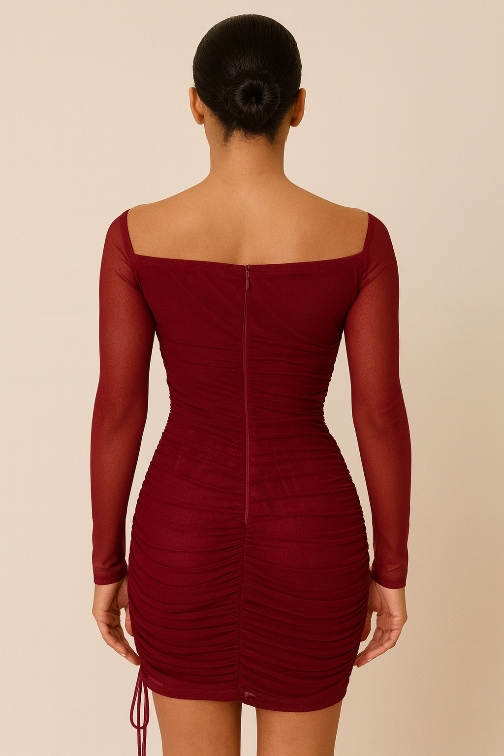 one-shoulder mini dress featuring a sheer long sleeve, fitted ruched detailing throughout, and an adjustable side drawstring,