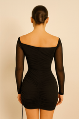 one-shoulder mini dress featuring a sheer long sleeve, fitted ruched detailing throughout, and an adjustable side drawstring,