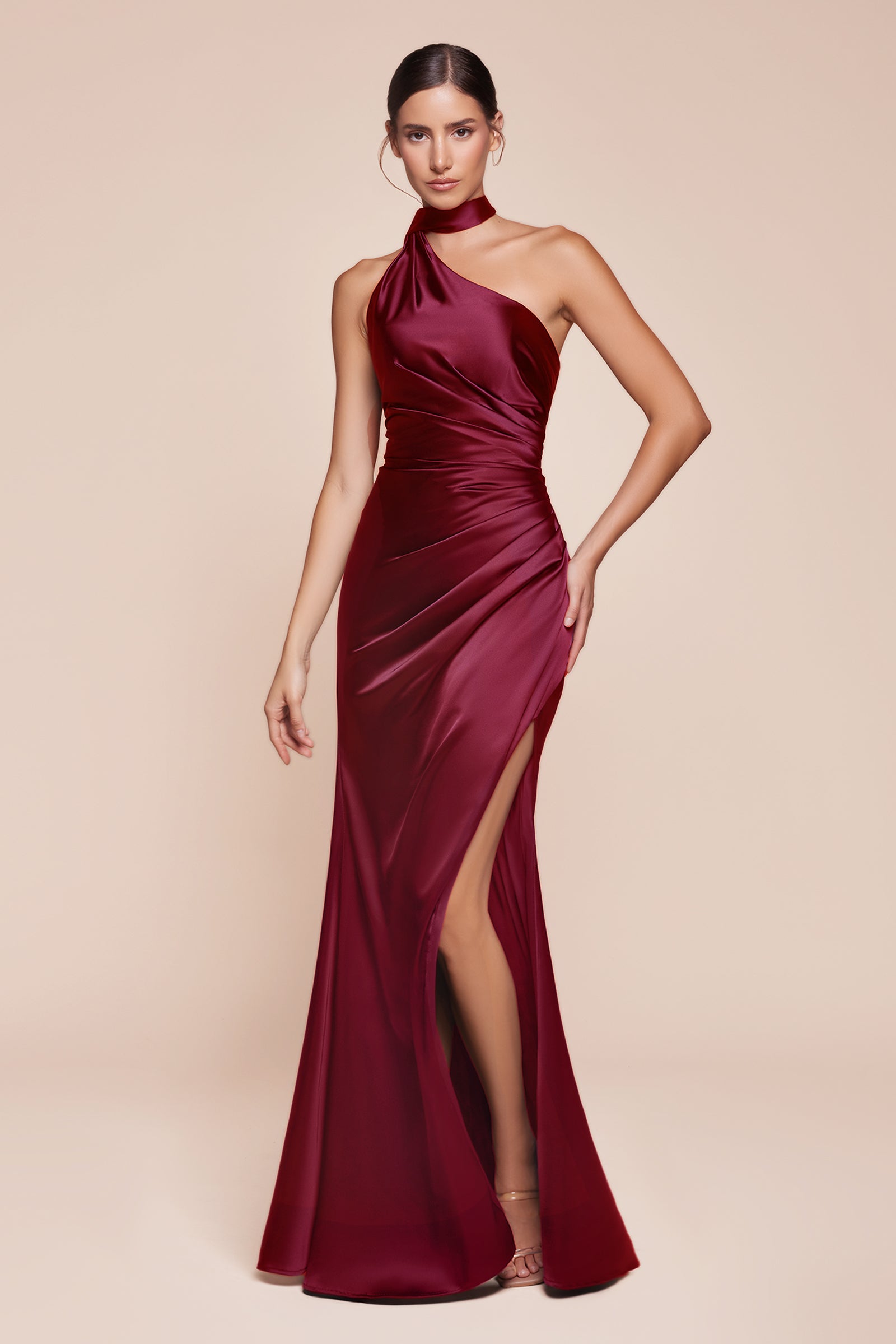 fitted gown showcases a chic one-shoulder wrap halter neckline, with a gathered waistline and elegant leg slit for added allure