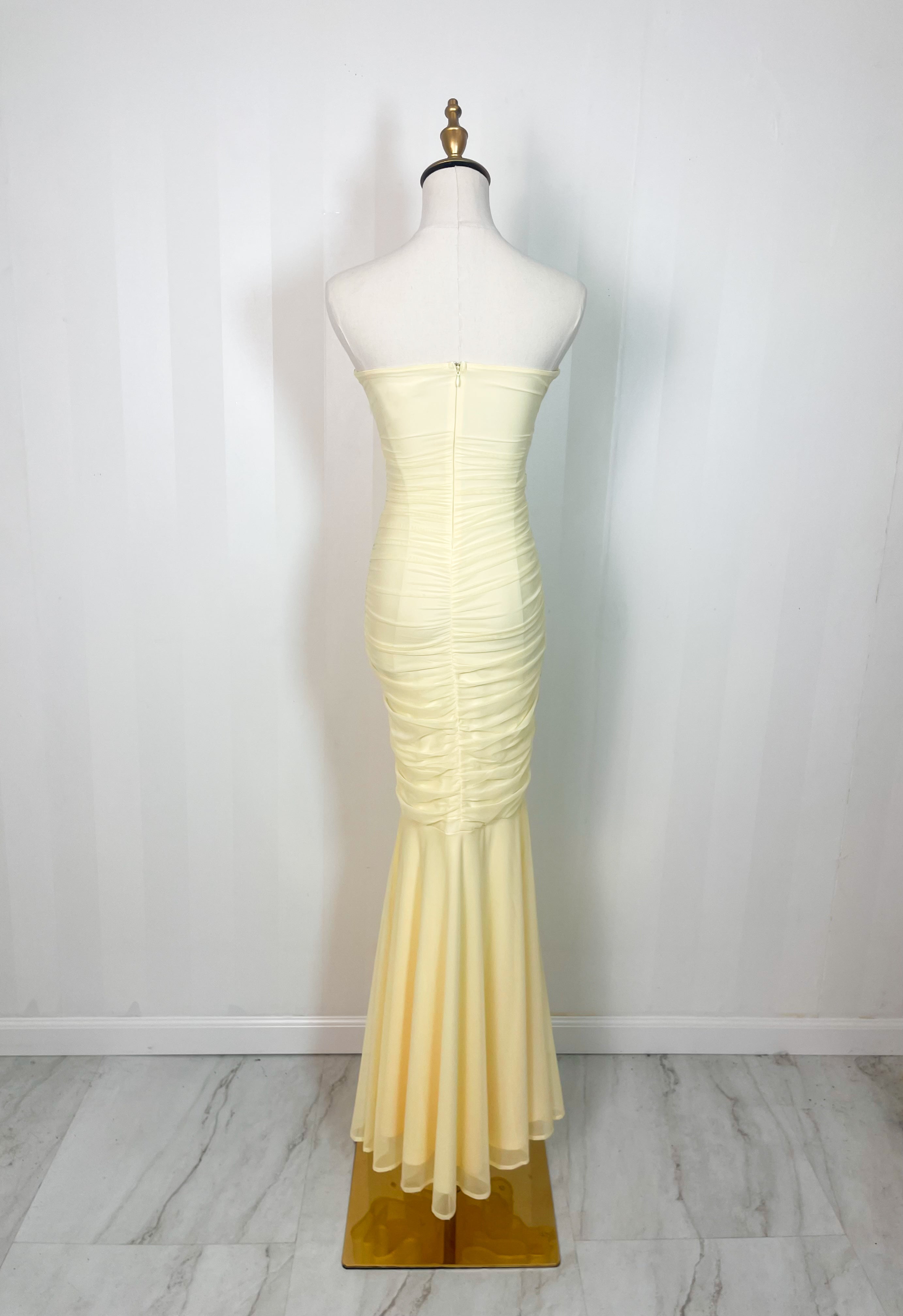 Yellow strapless ruched maxi dress with flared hem displayed on mannequin