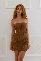Model wearing a mocha strapless mini dress with layered ruffle detailing throughout