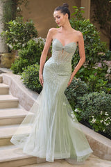 Woman in a strapless, beaded evening gown standing outdoors on steps with greenery.