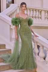 A woman models a floor-length sage green gown with voluminous ruffled puff sleeves, a fitted bodice, and vertical beadwork, standing on outdoor stone steps beside a white balustrade.