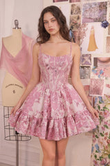 Woman wearing a pink floral dress in a room with mannequin and fabric.