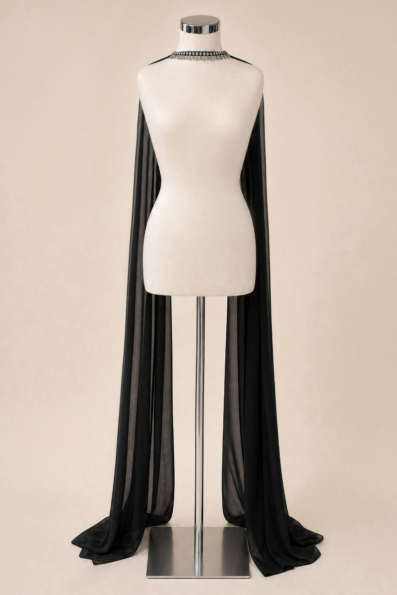 A black sheer cape-style drape with a short train, displayed on a white mannequin torso against a plain beige studio background.