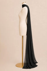 A long, flowing black sheer scarf or shawl draped over a cream-colored dress form on a gold stand, set against a solid light beige background.