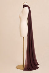 A long, sheer dark plum scarf draped over a cream dress form mannequin on a gold stand, set against a solid beige background.