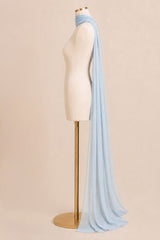 A light blue sheer scarf draped over a cream-colored dress form mannequin on a gold stand, set against a solid beige background.