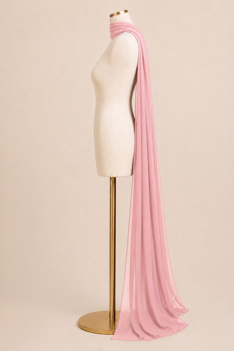 A long, lightweight pink scarf draped over a cream-colored dress form mannequin on a gold stand, set against a solid light beige background.