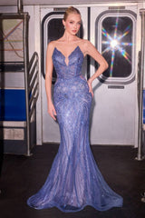 Woman in a blue evening gown standing in a subway car.