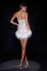 Woman wearing a white dress with feather details on a black background