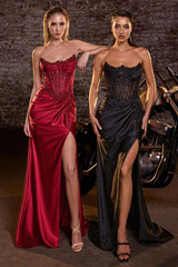 Two women in elegant evening gowns standing next to a motorcycle with a brick wall background.