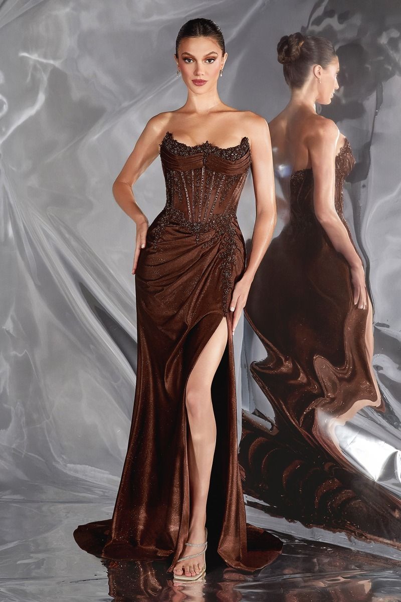 Woman wearing a brown evening gown with a high slit on a gray background
