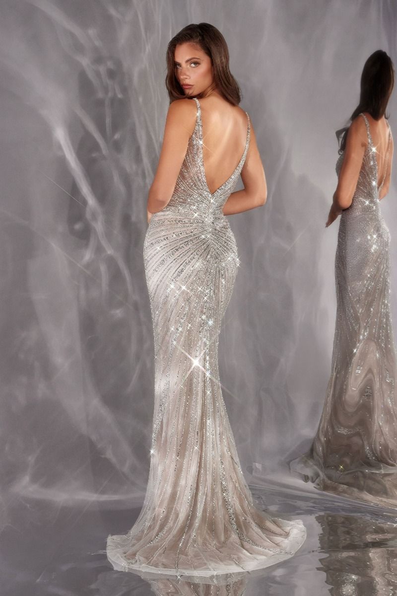 Woman wearing a sparkling silver evening gown against a gray background