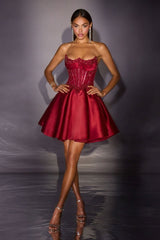 Woman wearing a red strapless dress against a dark background