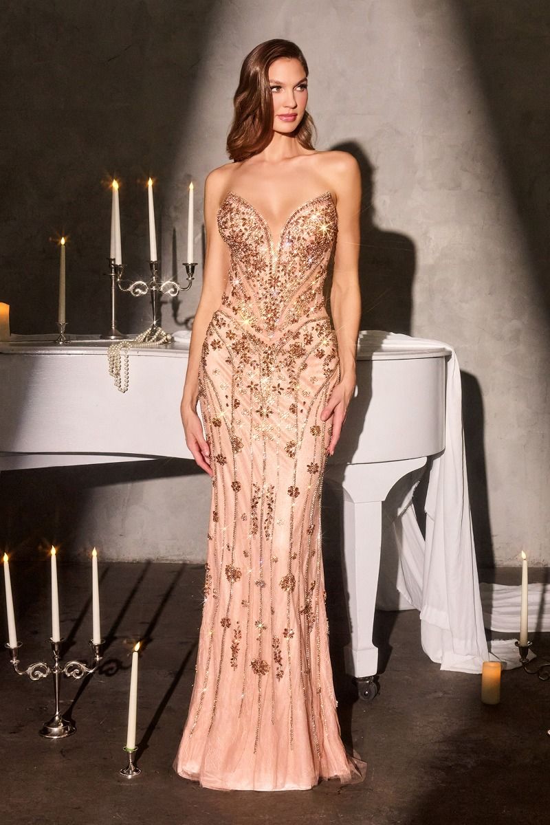Woman in a strapless, embellished evening gown standing in front of a piano with candles.