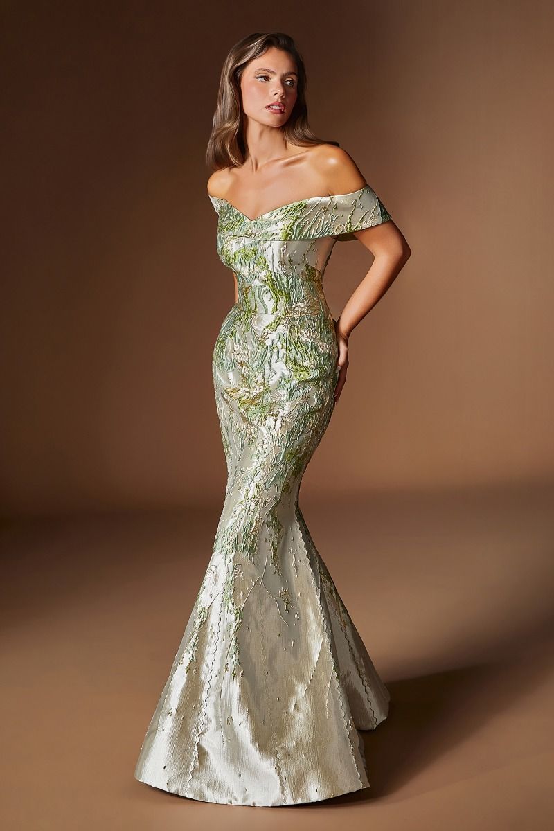 Woman wearing a green off-shoulder gown against a brown background