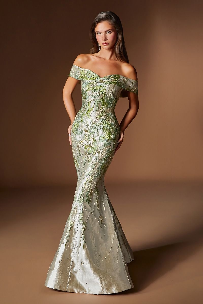 Woman wearing a green off-shoulder evening gown against a brown background