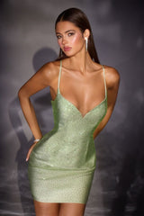 Woman wearing a green sequin dress against a dark background