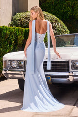 Model wearing a fitted gown featuring a draped bodice with sheer overlay, high side slit, and matching scarf accessory