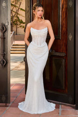 A woman models a strapless white mermaid-style gown with a fitted corset bodice and a flared lace skirt, standing in front of an open dark wooden door.