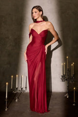 Woman wearing a burgundy evening gown against a dark background with candles.