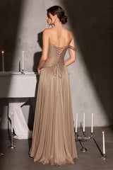 Woman in a long, elegant dress standing in a dimly lit room with candles.