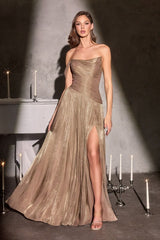 Woman in a gold evening gown standing in a dimly lit room with candles.