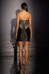 Model wearing a black leather corset dress with intricate detailing on a dark background