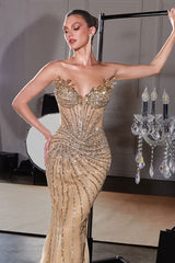 Woman wearing a gold beaded evening gown in an indoor setting.
