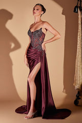 Woman wearing a burgundy evening gown with a high slit on a beige background