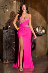 Woman in a pink evening gown with a high slit, standing in a dimly lit room with industrial decor.
