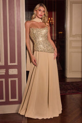A woman models a formal evening gown with a strapless sweetheart bodice covered in shimmering gold sequins and a flowing champagne beige skirt, set against an elegant interior doorway.