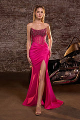 Model wearing a strapless gown featuring a beaded corset bodice, ruched waist detailing, and high side slit